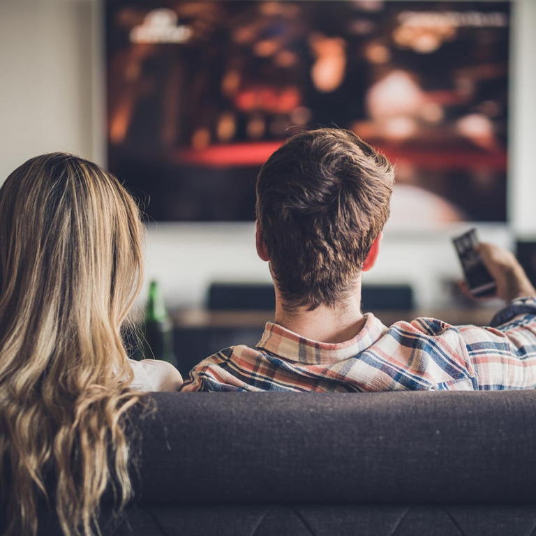 Couple watching television in the living room